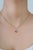 This elegant pendant features a vibrant 0.37 ct natural round ruby, set in 14K yellow gold. The center stone measuring 5.3...