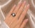 Estate 18K white gold hexagon band ring featuring black diamonds. This modern ring is set with numerous brilliant round...