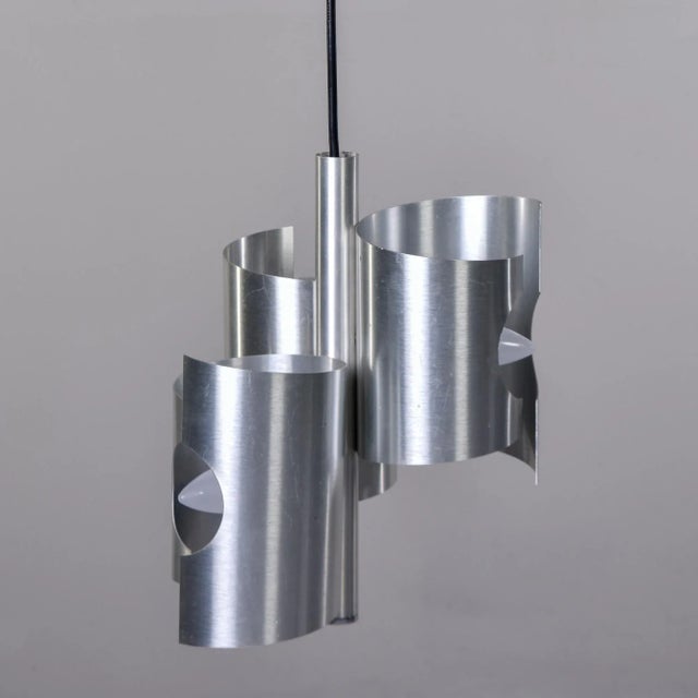 Found in Italy, this circa 1960s hanging pendant has three staggered aluminum tubes with cut outs for the bulbs. Standard...