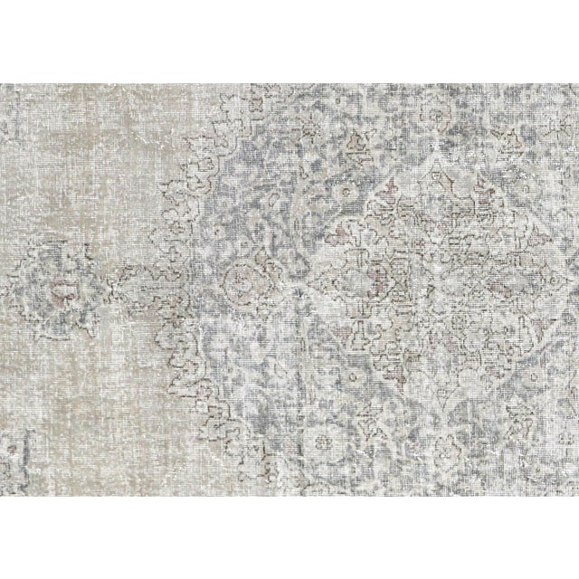 This vintage Turkish Oushak rug, measuring 7'7" by 11', is expertly handwoven with wool on a wool foundation in the Oushak...