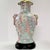 Table lamp with Fu Dog detail on the sides. Lamp body hasa a pattern of stylized feathers, flowers, and geometric motifs....
