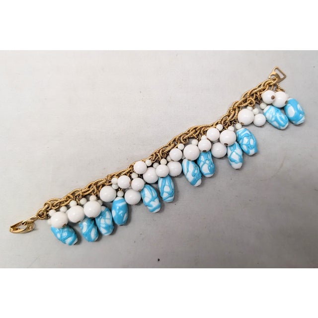 1967 goldtone white and turquoise art glass charms with round white bead dangle accents bracelet with fold over clasp....