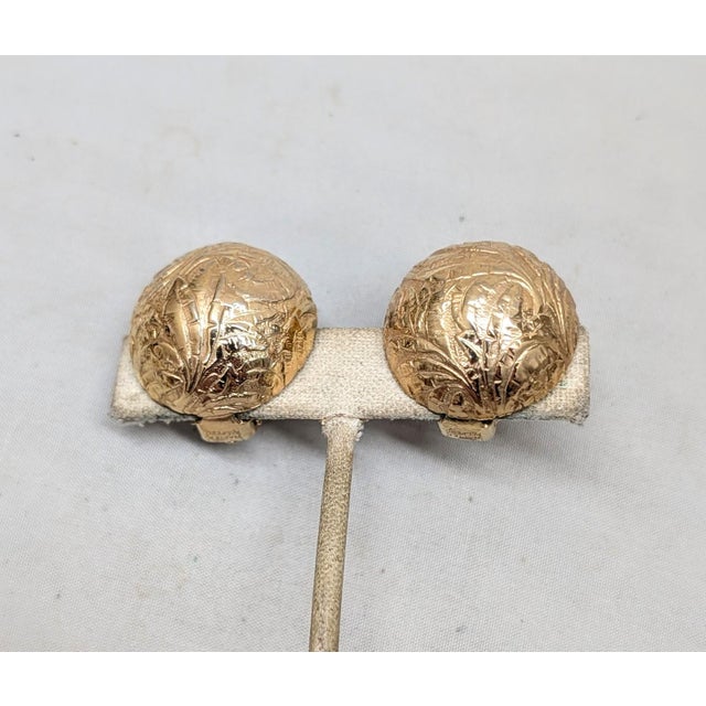 1960s round domed goldtone etched foliate design butterfly clip earrings. Marked "NAPIER PAT. PEND." on the clips and the...