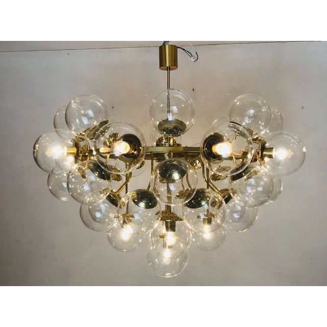 The Chandelier is in a very good original condition. It is possible to have spare glass balls. This piece is attributed to...