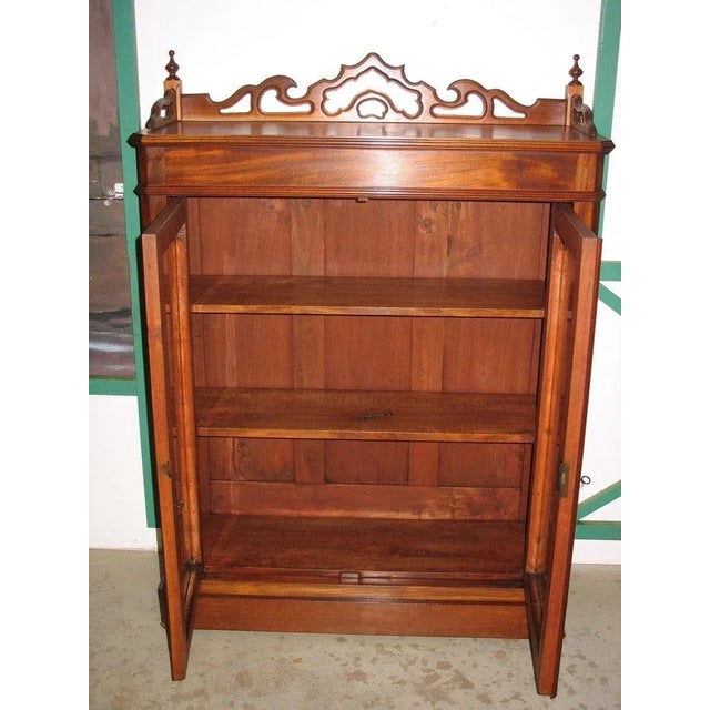 Small low mahogany display case opening with two glass doors. Small gallery on top. Interior lined with 2 shelves. Second...