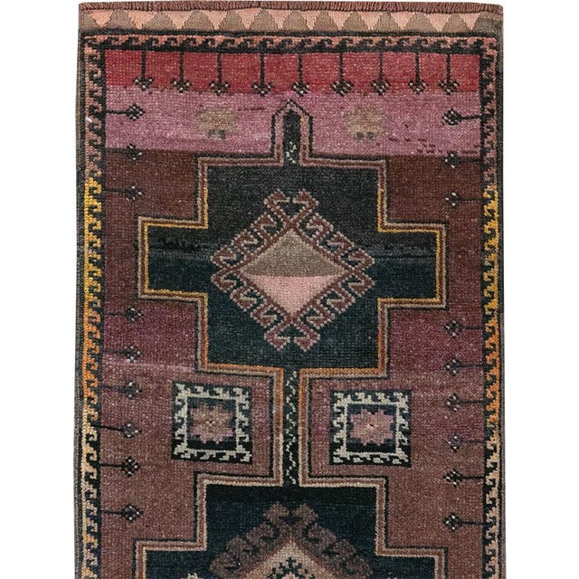 This mid-20th-century Turkish Anatolian long runner presents a striking procession of stepped cruciform medallions...