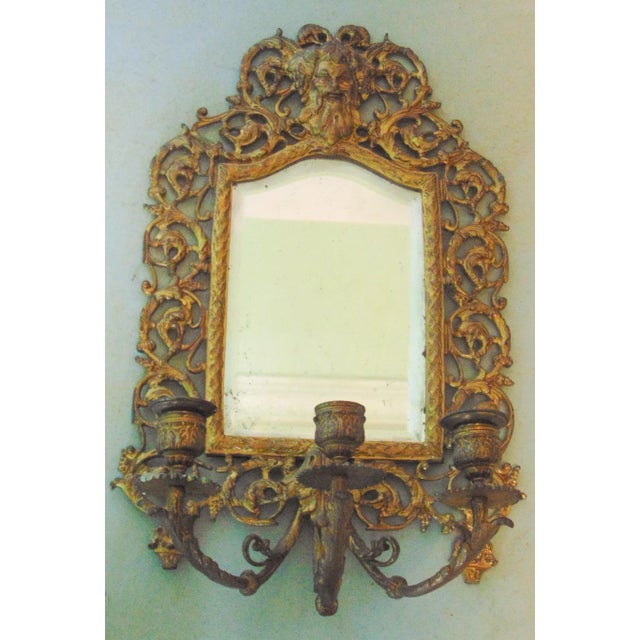 A pair of Victorian Mirrored Candle Sconces. Gilt bronze reticulated frame, northwind face on crest, 3 arm candle holders,...