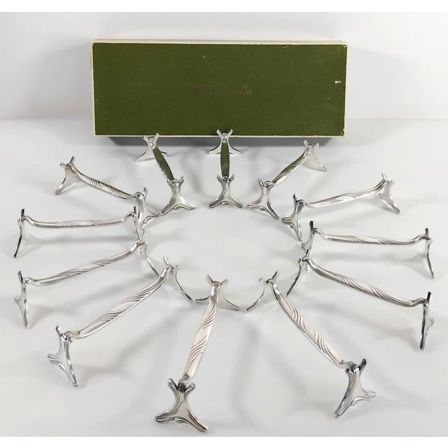 Twelve Christofle knife holders with wave motifs "Gramont" model. France, 1950. Dimensions: Height: 1 inch, Length: 3.7...