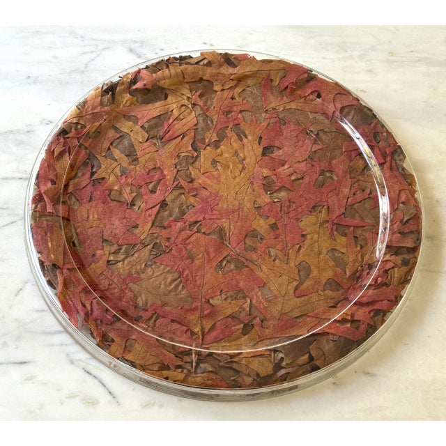 Vintage 1970's Christian Dior large lucite serving tray. Features leaves of reds and browns. 16 1/2" diameter. 1" high....