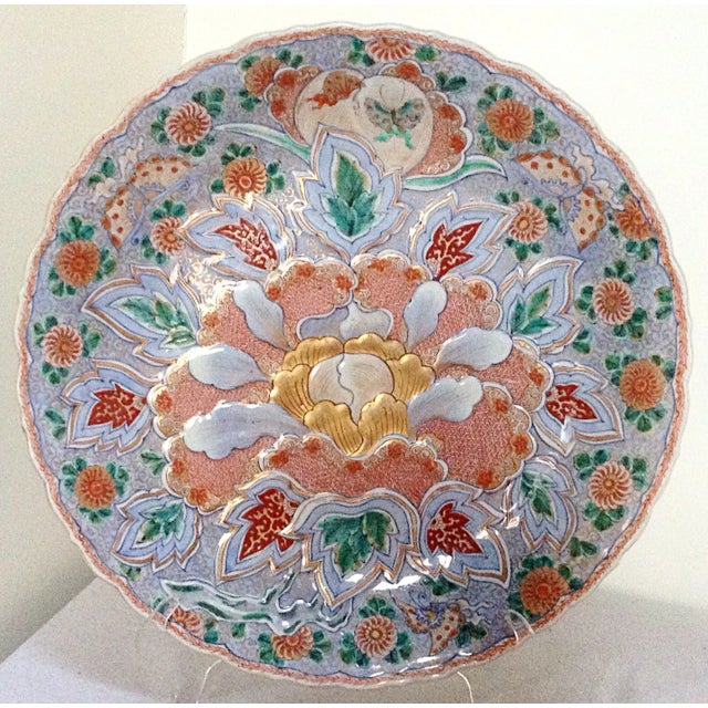 This is a large antique Asian charger that has beautiful finely detailed designs on the front and back.
