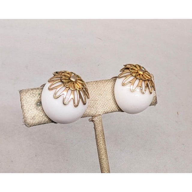 1950s goldtone filigree top round domed white resin butterfly clip earrings. Marked "NAPIER PAT. PEND." on the clips....