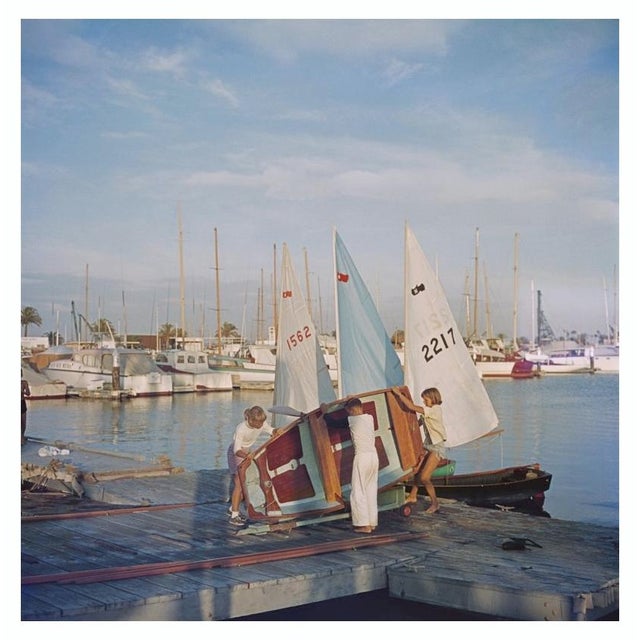 Sailing Dinghy 1956 A boy and two girls lifting a sailing dinghy off its trailer, San Diego, California, October 1956....
