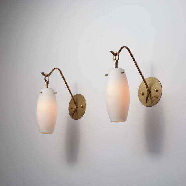 A refined pair of italian wall sconces from the 1950s, characterized by elegant proportions and a light, sculptural...