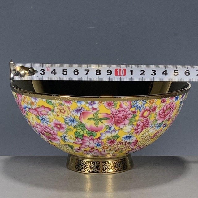 A vibrant Chinese porcelain bowl featuring a bright yellow ground decorated in a dense "Millefleur" (thousand flowers)...