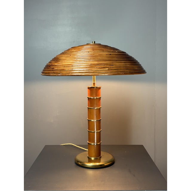 Absolutely stunning table lamp in patinated brass and wood with pencil reed shade attributed to Italy 1960s. The lamp is...