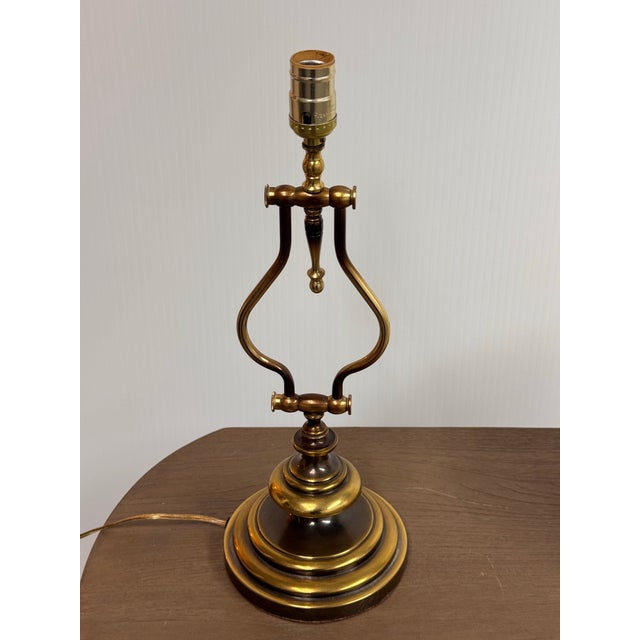 Design Plus Gallery presents a Vintage Lyre Form Brass Tone Table Lamp. This table lamp showcases a classical lyre-...