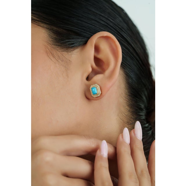 These stud earrings feature 1.34 carats of turquoise set in 14k yellow gold. Each turquoise measuring 6.1 x 4.1 mm,...