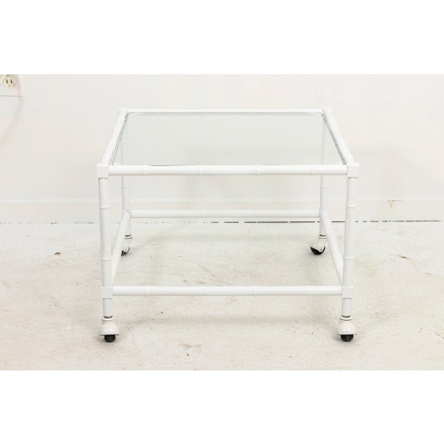 Faux bamboo side table on casters with white powder coat finish on steel. New glass top.