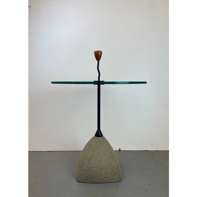 Sculptural Post-Modern side table featuring a textured concrete base, a black enameled steel central column, and a round...