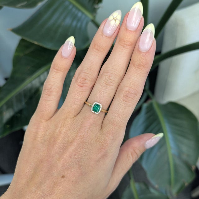 Elegant Colombian emerald ring featuring a vivid 6×5mm center stone, accented by sparkling earth-mined diamonds. Crafted...