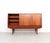 Danish design highboard from the 1960s, crafted in teak veneer. The unit features three sliding doors and three spacious...