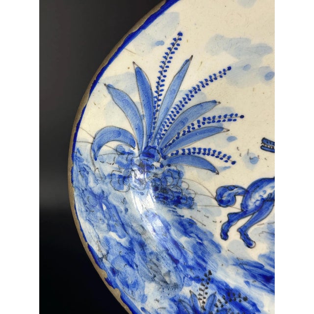 This remarkable oval faience platter, hand-painted in intense cobalt blue on a pale tin-glazed ground, is an authentic...