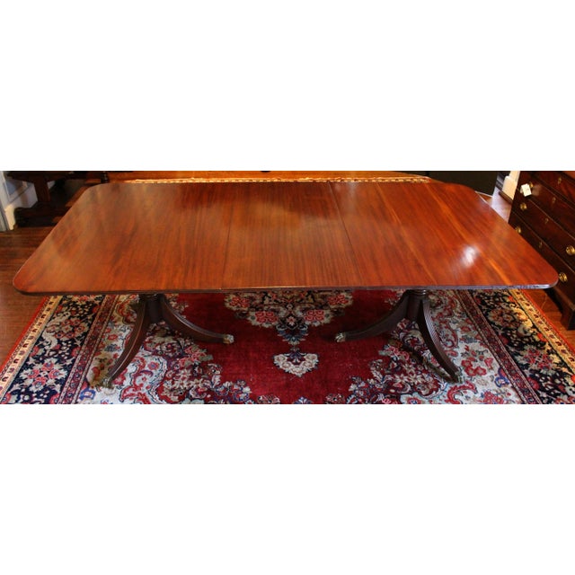 Circa 1835 dining table of solid mahogany. English, William IV period. Raised on twin pedestals, each boldly turned with...