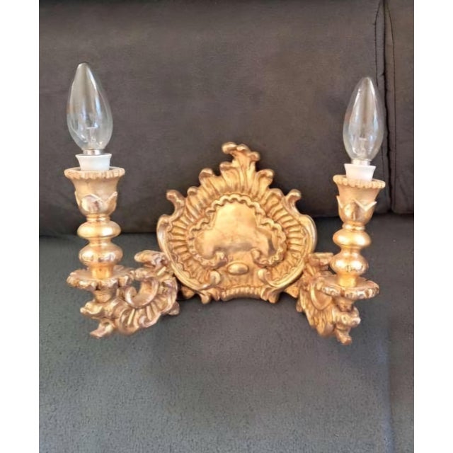 A decorative pair of 19th-century English style giltwood wall sconces, richly carved with scrolling acanthus leaves and...