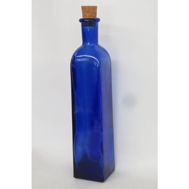 This vibrant vintage style bottle is made of stunning cobalt blue glass with a classic cork stopper. This bottle is slim,...