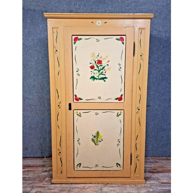 A charming, traditional-style cabinet, crafted from wood and entirely hand-painted, exemplifies the decorative taste of...
