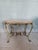 Antique hand-forged wrought iron coffee table with marble top, enclosed by a wooden frame that follows the entire line of...