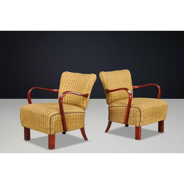 An elegant pair of Art Deco lounge chairs by Jindřich Halabala, dating from the 1930s. Sculptural bentwood armrests,...