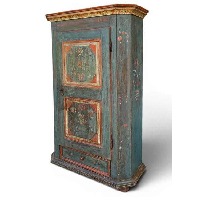 An antique painted Tyrolean cabinet, dated 1801. Crafted from spruce wood, this period piece features the quintessential...
