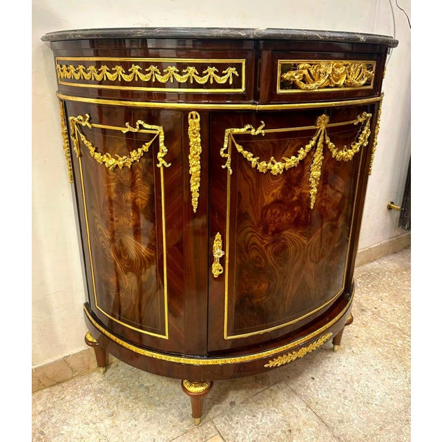 Bring timeless French elegance into your home with this magnificent Louis XVI-style demilune sideboard cabinet. Crafted...