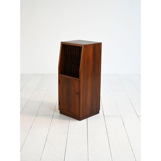 Dark wood cabinet with upper compartment for vinyl records and lower door with drawers. Made in the 1950s and 1960s. Dark...