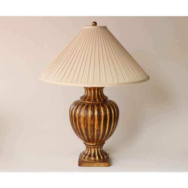 This vintage lamp base from Maison Le Dauphin France features a classic urn design with ribbed form and distressed gold...