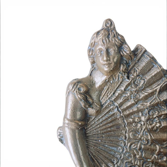 A decorative vintage trinket dish featuring an elegant female figure beside an elaborately detailed fan. Made from heavy...