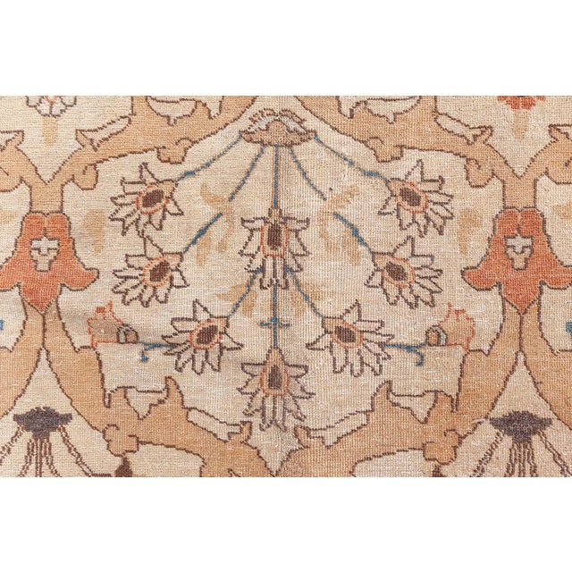 A late 19th century Persian Tabriz rug, the cream field with a restrained lozenge design formed by thick curvilinear...