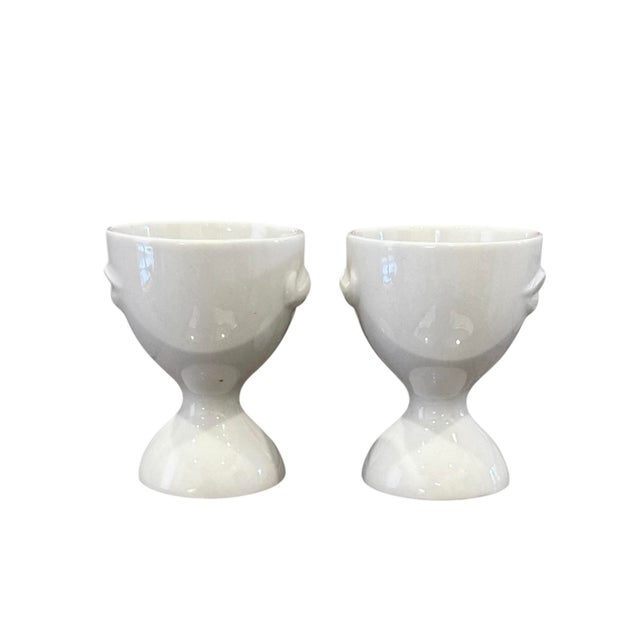 A quirky pair of egg cups by Jonathan Adler. Each features a pair of lips and mustache on opposing sides of a white...