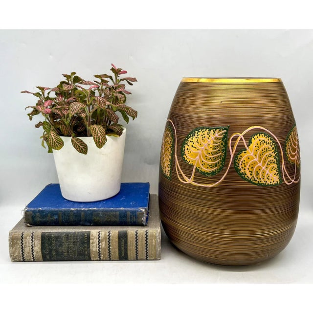 Gorgeous, oversized vase with a pattern of gold rings progressing down over the brown base. Features detailed vine pattern...
