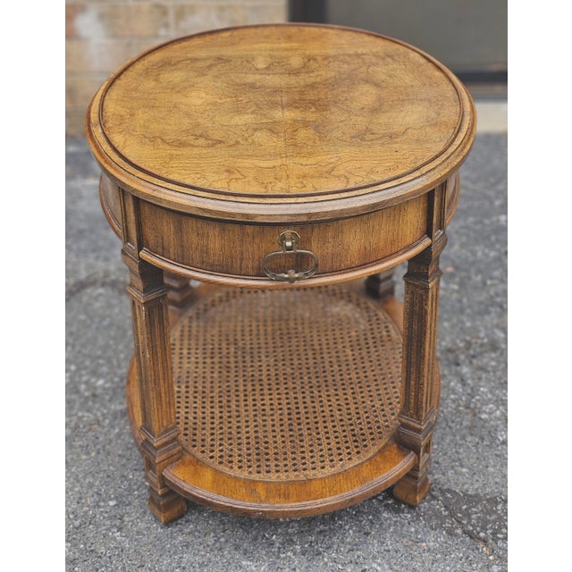 A Mid Century Walnut Burl and Cane Oval Side Table Measures 21.5" in width, 26" in depth and 23.5" in height.