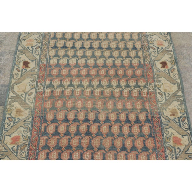 Hand-knotted in fine wool circa 1920-1930, this 3x10 antique Persian Tabriz runner rug is a rare and contemplative...