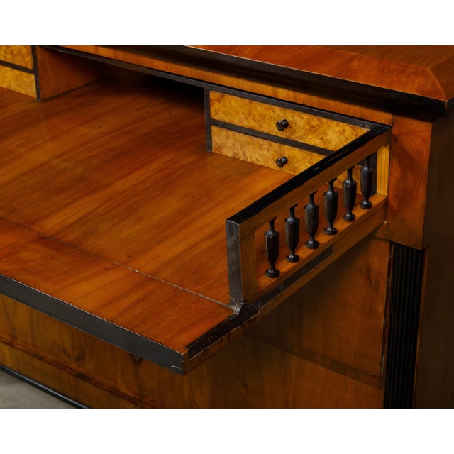A Biedermeier period walnut butler's chest from the 19th century with drop front desk, ebonized accents and inlaid...