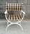 A single Campaign style patio chairs in white powder coated aluminum with brown and gold heavy duty vinyl upholstery in a...