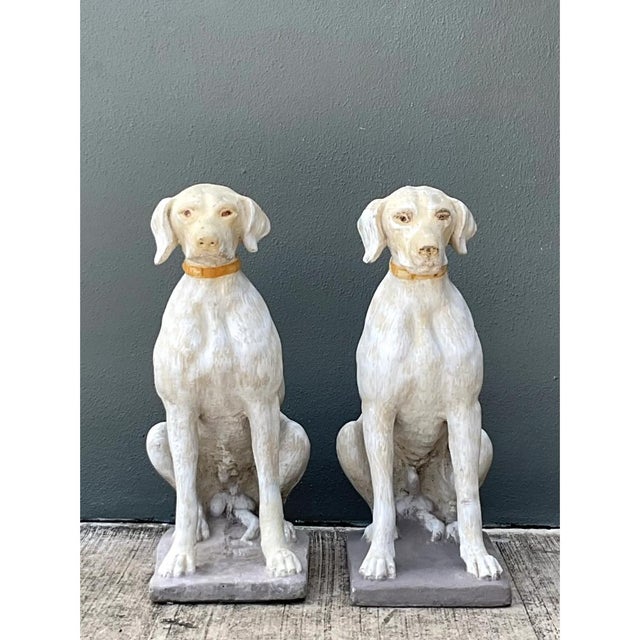 This charming pair of vintage cement dog sculptures captures the poised elegance and calm alertness of seated canines,...