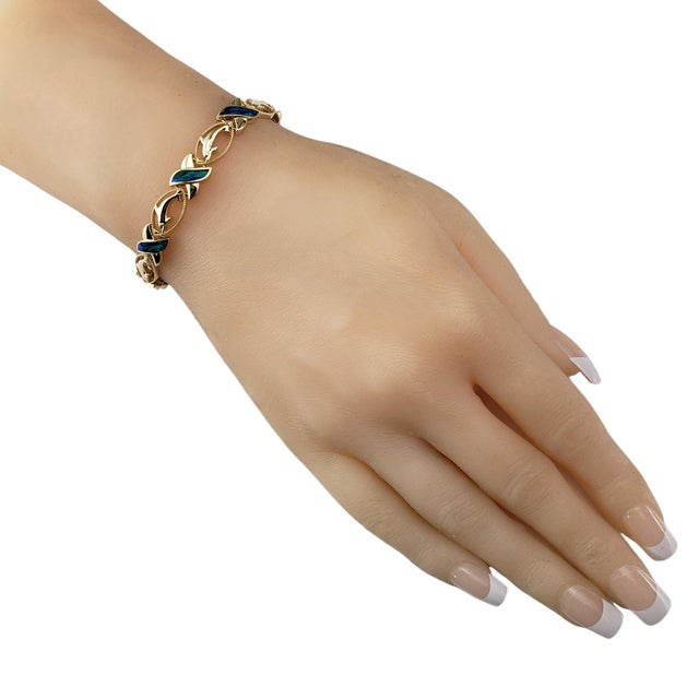 14 Karat Yellow Gold and Black Opal XO Dolphin Bracelet- This elegant XO style dolphin bracelet features eight tablet cut...