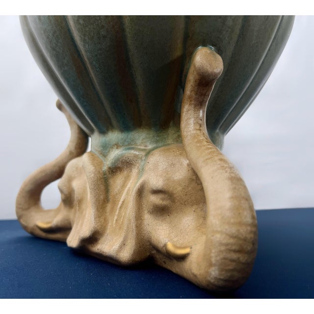 A striking vintage sculptural cachepot featuring three elephants supporting a ribbed lotus-form planter with a beautiful...