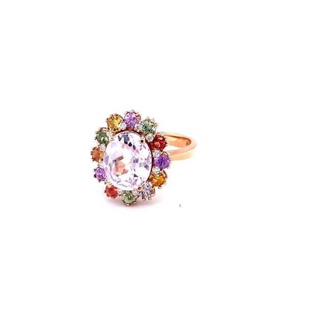 This ring has an Oval Cut Kunzite that measures at 9 mm x 11 mm and is 3.88 carats. It also has 12 Multi Colored Sapphires...