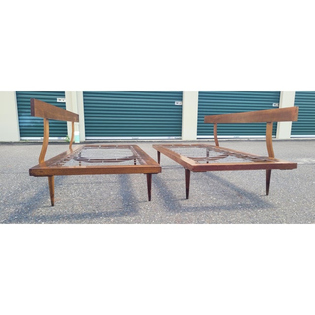 A fine pair of 1950 60s mid-century modern day beds. Features intact Springs tapered legs and free-floating backrest....