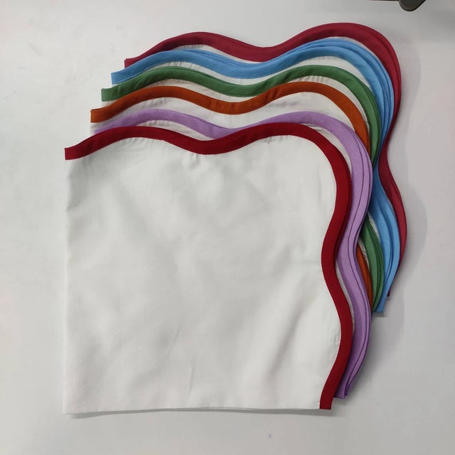 These scalloped white napkins have a contrast color piped around the border - adding a fun twist to your tabletop! Pair...